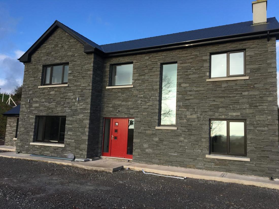 Finished two-storey house clad in natural slate stone