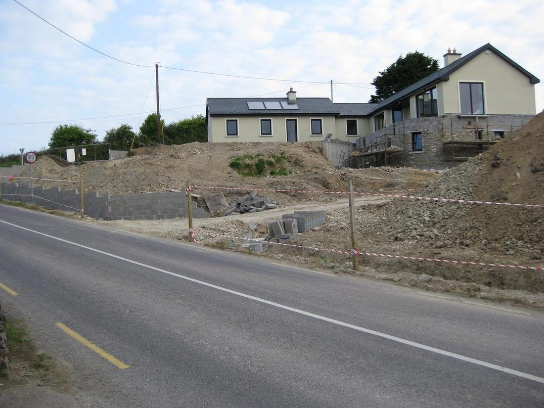 Bare hillside site before stone walls