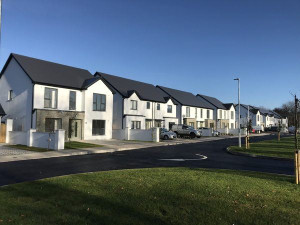 Completed street of homes with natural stone facades, Barters Wood, Tower Co. Cork