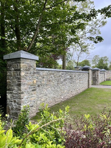 Natural stone boundary wall with pillars