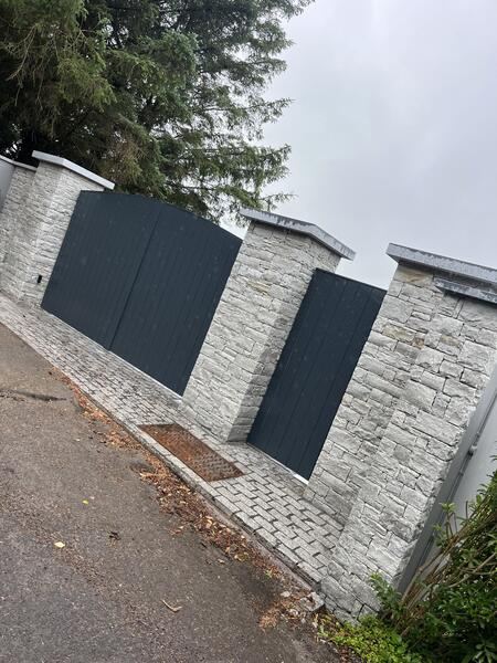 Stone entrance with pillars and cobble apron