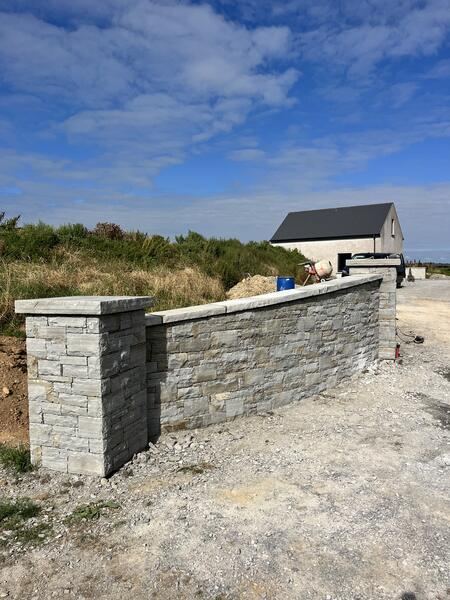 Curved natural stone wall with coping