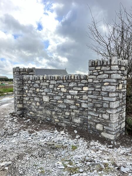 Dry stone masonry wall with pillars