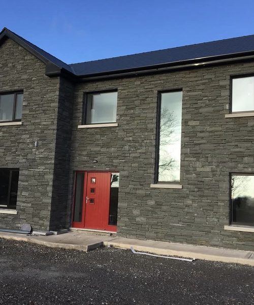 Stone-clad house gable with feature window surround, Co. Cork