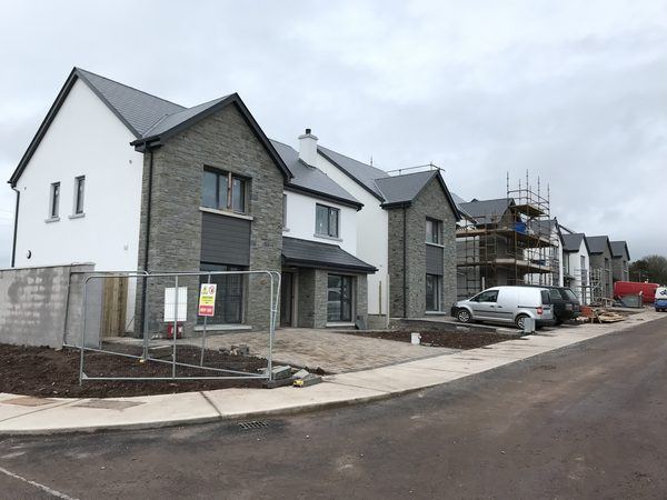 New homes with stone gables along the street, The Orchard