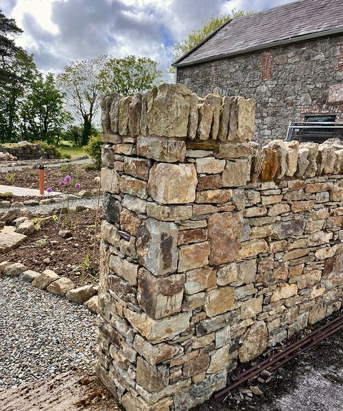 Dry stone wall pillar detail in warm sandstone