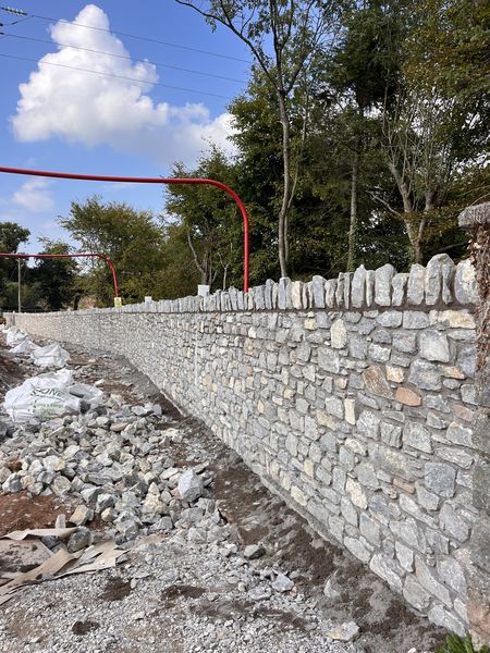 Long run of completed limestone wall with castellated coping, Water Rock Road scheme, Midleton